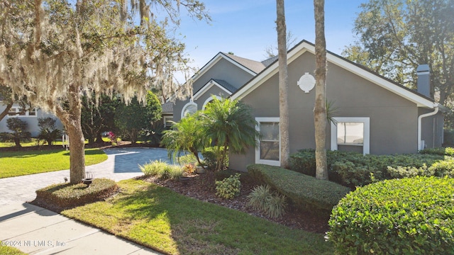 133 Sawmill Lakes Blvd, Ponte Vedra Beach, FL 32082 - view of front of property featuring stucco siding, decorative driveway, a front lawn, and a chimney