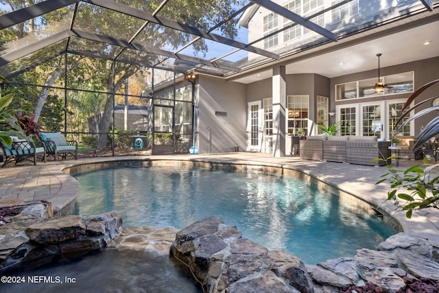 view of swimming pool with outdoor lounge area, french doors, ceiling fan, a lanai, and a patio area