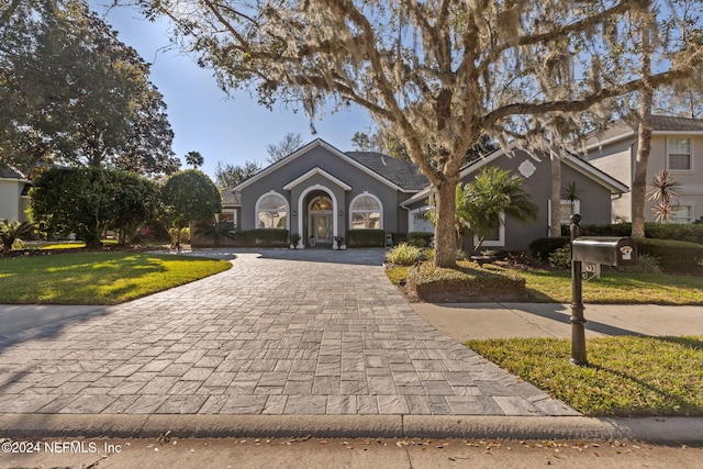 133 Sawmill Lakes Blvd, Ponte Vedra Beach, FL 32082 - view of front of house with curved driveway, a front yard, and stucco siding
