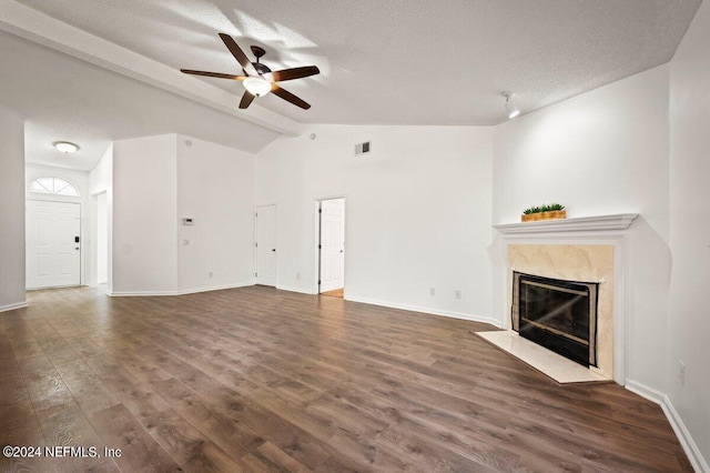 unfurnished living room featuring ceiling fan, hardwood / wood-style floors, a high end fireplace, and lofted ceiling with beams