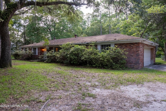 ranch-style home featuring an attached garage, brick siding, and driveway