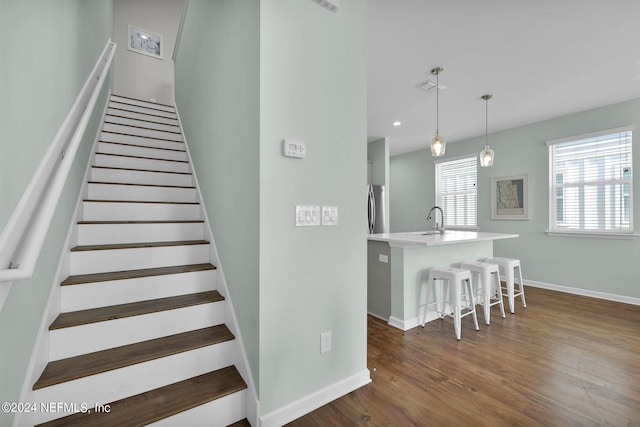 staircase with sink and hardwood / wood-style floors