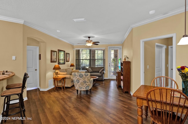 living room with arched walkways, dark wood-style floors, visible vents, and crown molding