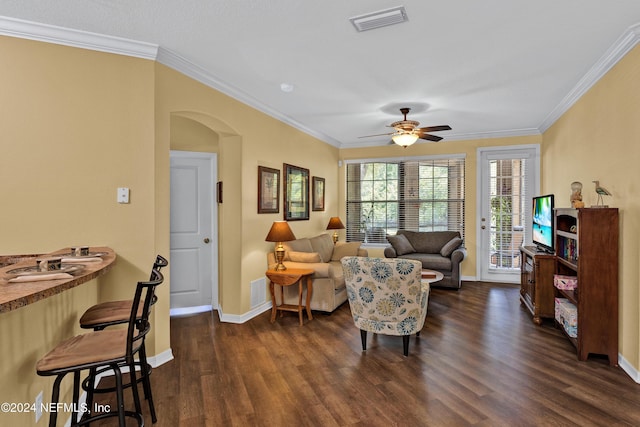 living room featuring arched walkways, dark wood-type flooring, visible vents, and crown molding