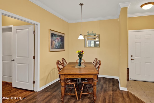 dining area with dark wood-style floors, crown molding, and baseboards