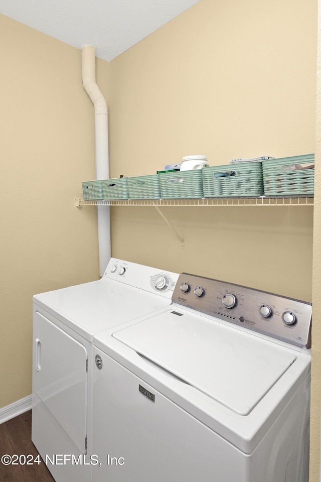 clothes washing area with laundry area, dark wood-type flooring, independent washer and dryer, and baseboards