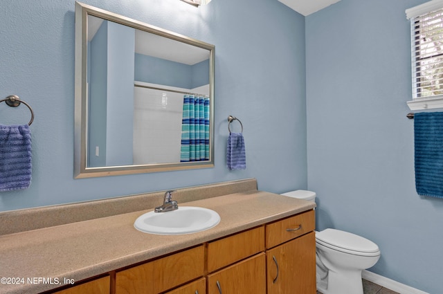 bathroom with a shower with shower curtain, vanity, and toilet