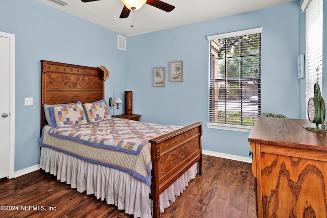 bedroom with dark wood-style floors, visible vents, and multiple windows