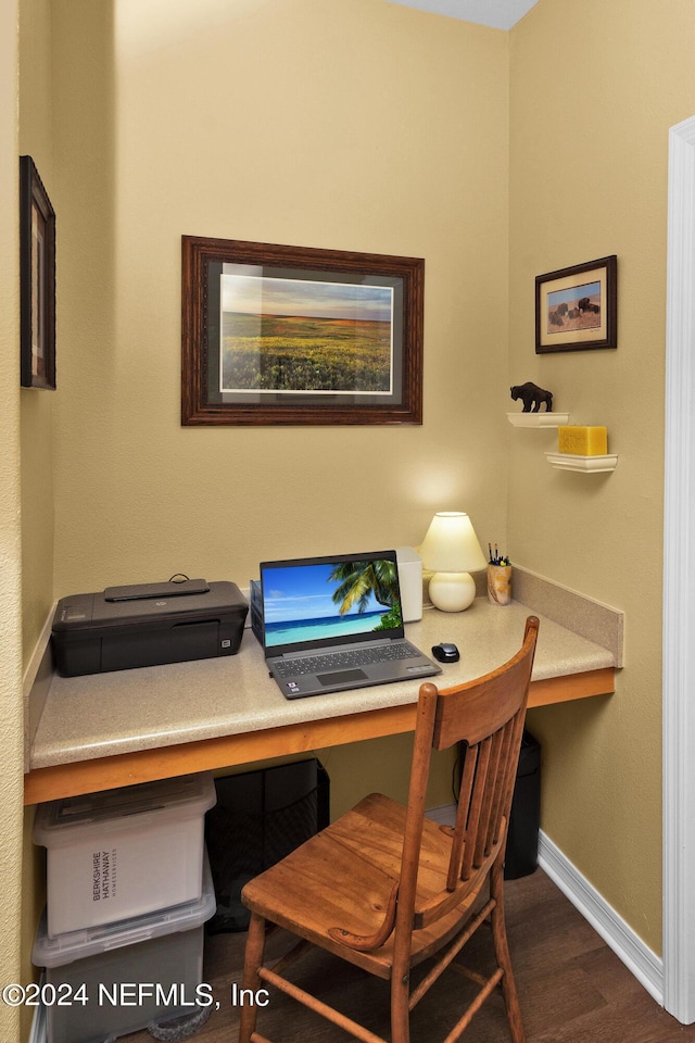 office space featuring dark wood-style flooring, built in study area, and baseboards