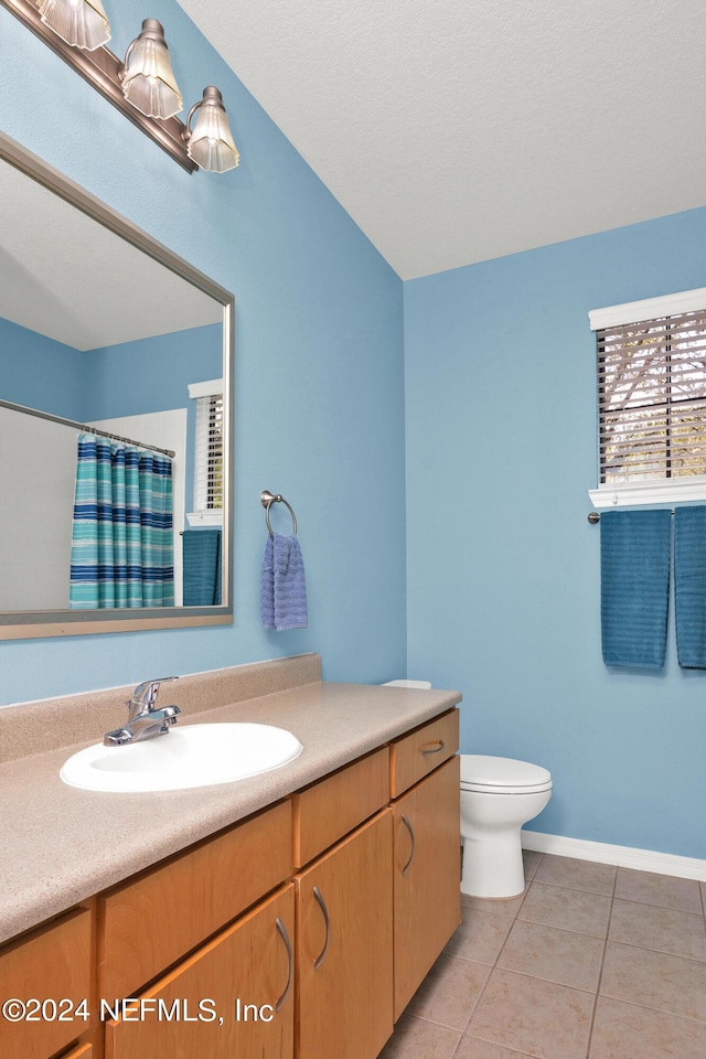 bathroom with baseboards, toilet, tile patterned floors, curtained shower, and vanity