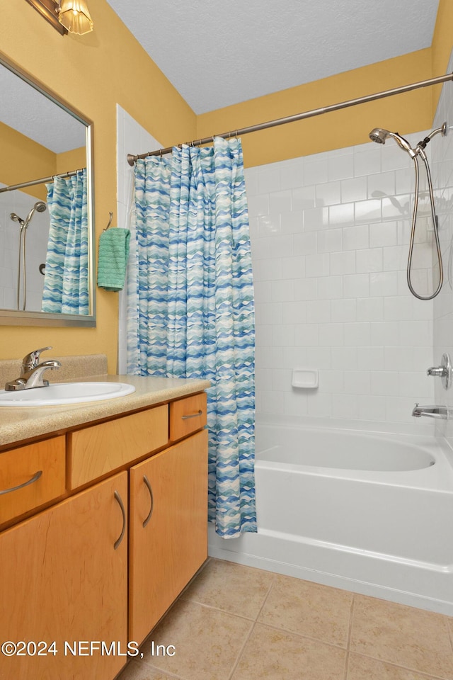 full bath featuring vanity, shower / bath combo with shower curtain, a textured ceiling, and tile patterned floors