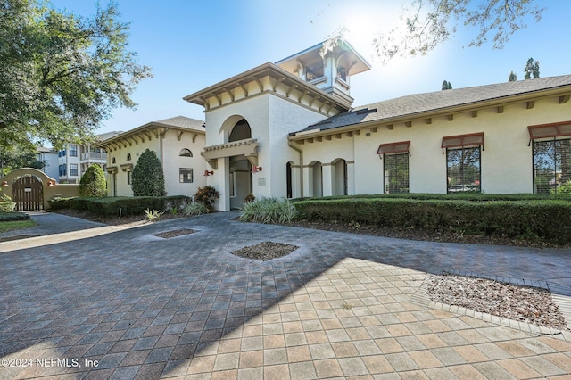 view of front of property with a gate and stucco siding