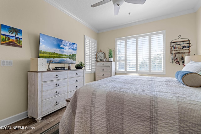 bedroom with dark wood-style flooring, ornamental molding, multiple windows, and a ceiling fan