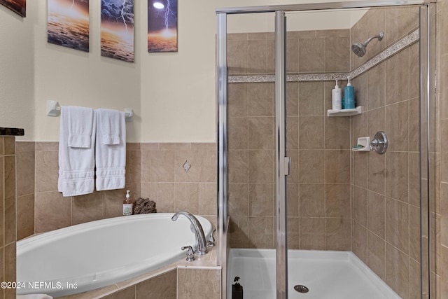 bathroom with a stall shower and a bath