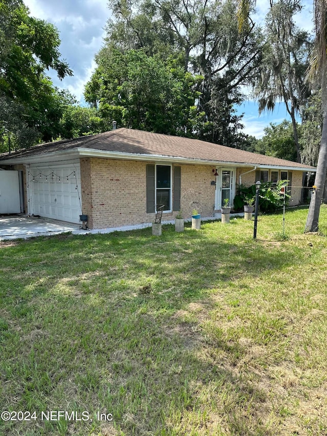 ranch-style home with a garage and a front lawn