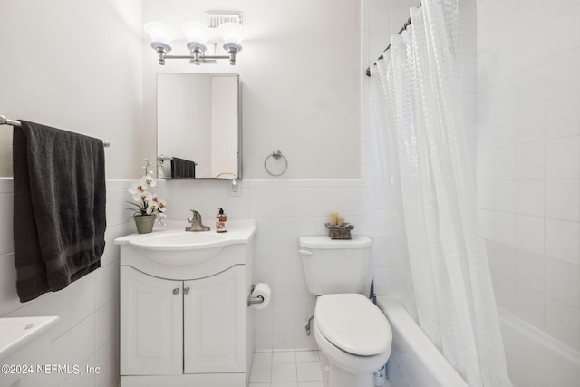 full bathroom with vanity, toilet, tile walls, and shower / bath combo