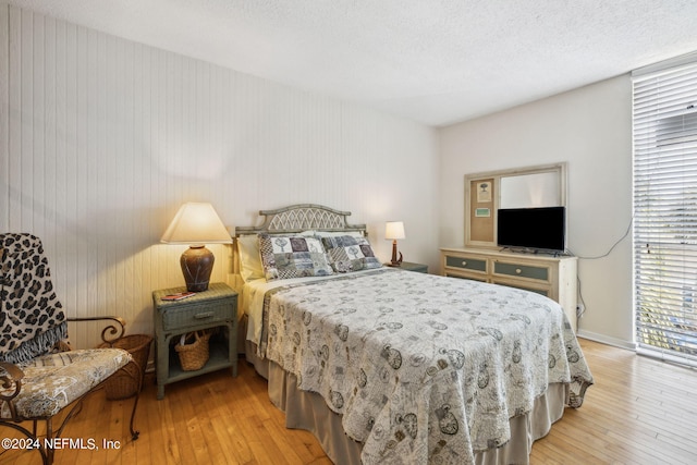 bedroom with a textured ceiling and light wood-type flooring