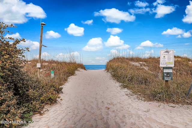 surrounding community featuring a beach view and a water view