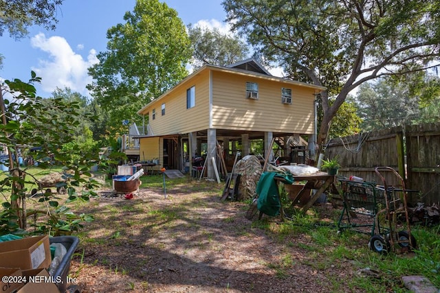 rear view of house with a carport and fence