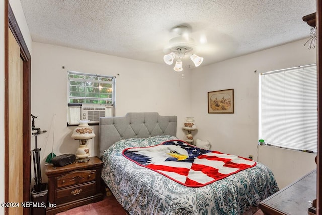 bedroom with cooling unit and a textured ceiling