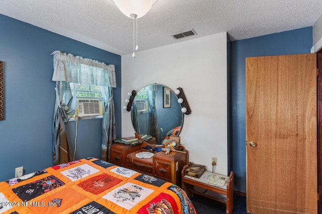 bedroom with visible vents, a textured ceiling, and cooling unit