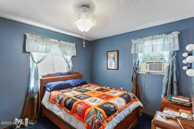 bedroom with cooling unit, a textured ceiling, and a ceiling fan