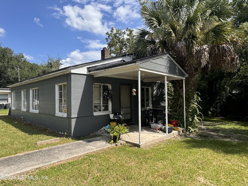 bungalow-style house with a front yard and covered porch