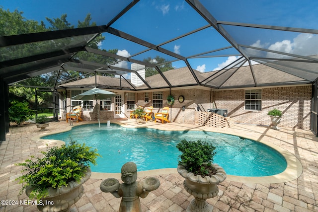 view of swimming pool featuring pool water feature, a lanai, and a patio area