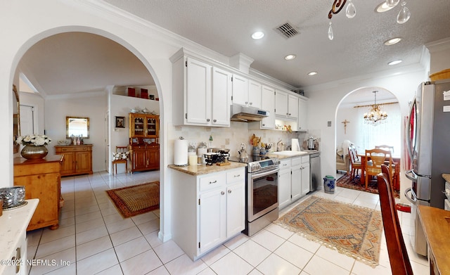 kitchen with plenty of natural light, stainless steel appliances, light tile patterned flooring, and decorative backsplash