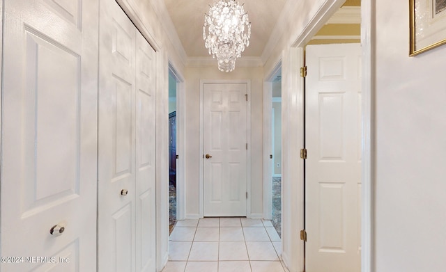 corridor featuring light colored carpet, crown molding, and a notable chandelier