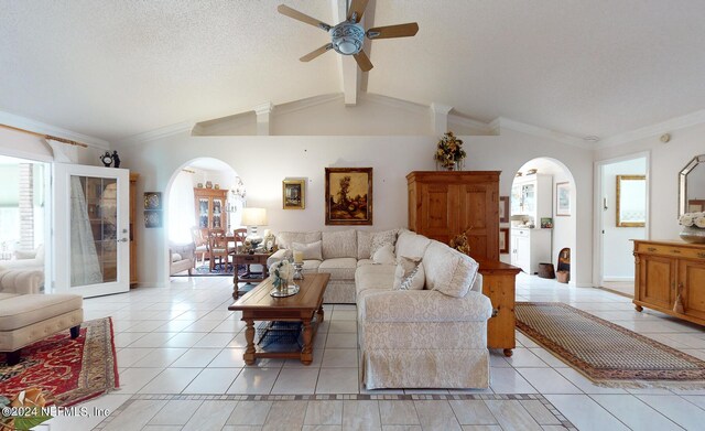 living room with crown molding, a textured ceiling, ceiling fan, lofted ceiling with beams, and light tile patterned flooring