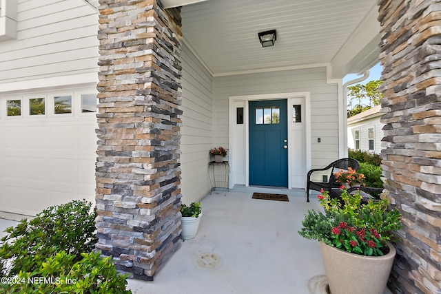 entrance to property with a garage and covered porch