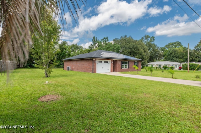 ranch-style house with a front lawn, solar panels, and a garage