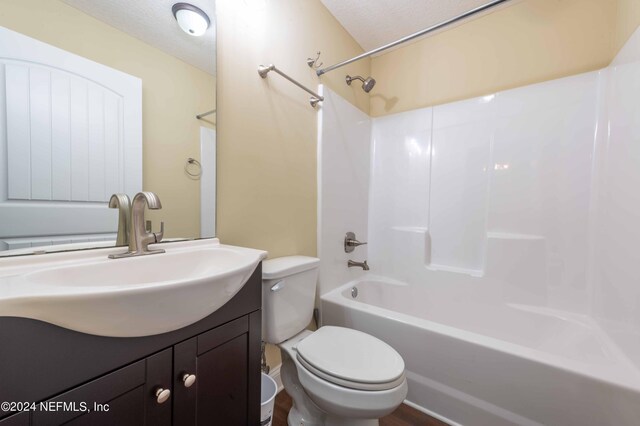 full bathroom featuring shower / bathing tub combination, toilet, a textured ceiling, and vanity