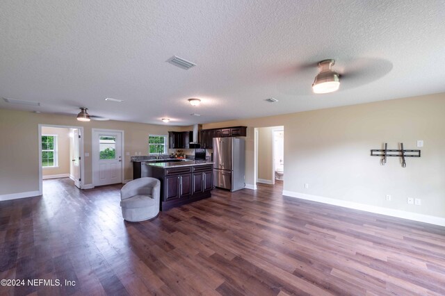 kitchen with wood-type flooring, dark brown cabinets, a textured ceiling, ceiling fan, and stainless steel fridge