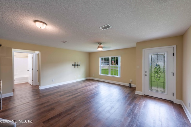 interior space featuring a textured ceiling and dark wood-type flooring