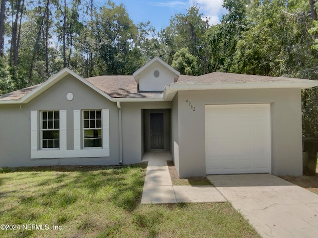 ranch-style house featuring a garage and a front lawn