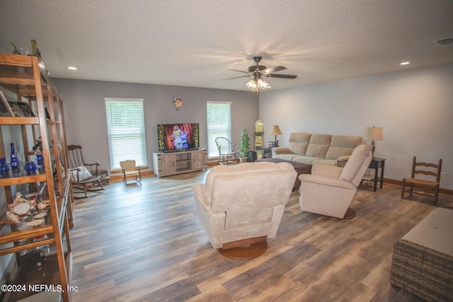 living room with ceiling fan, hardwood / wood-style flooring, and a textured ceiling