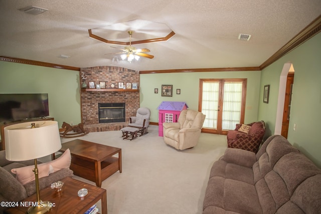 living room with ceiling fan, carpet flooring, a textured ceiling, and a brick fireplace