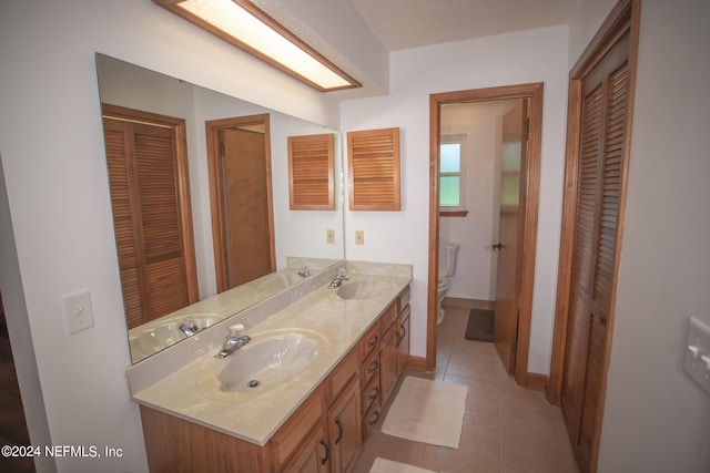 bathroom featuring tile patterned floors, vanity, and toilet