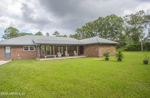 rear view of property with a patio area and a yard