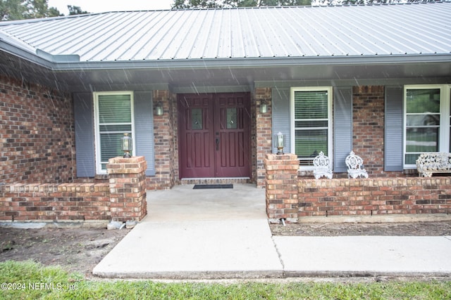 view of exterior entry with a porch