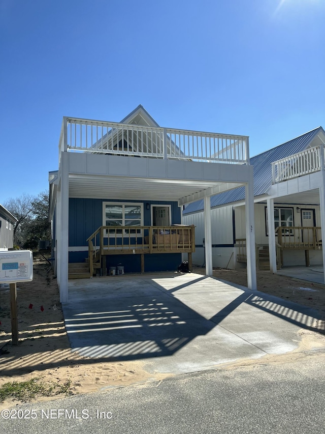 view of front of home featuring a carport, concrete driveway, and board and batten siding