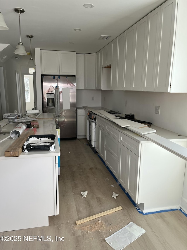 kitchen featuring white cabinets, light countertops, and stainless steel fridge with ice dispenser