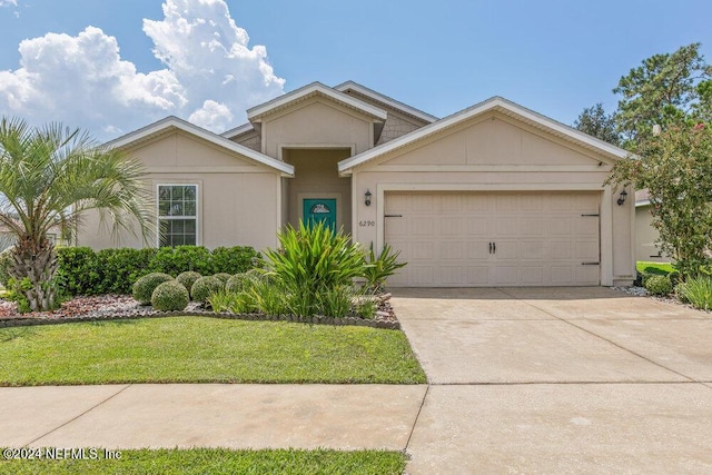 ranch-style house featuring driveway, a garage, and a front lawn