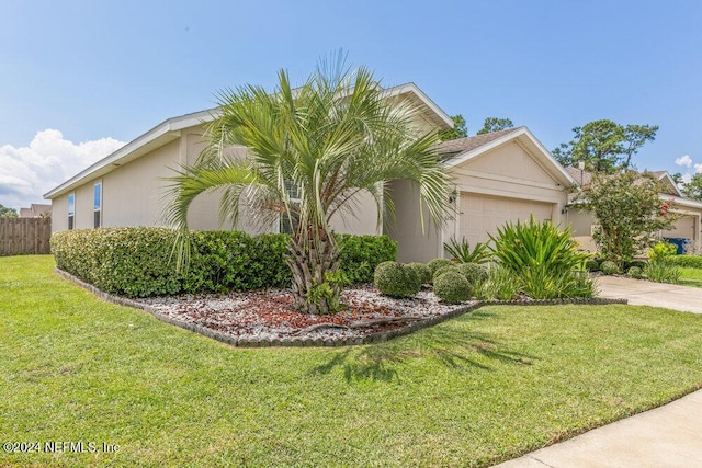 view of side of home with concrete driveway, a lawn, an attached garage, and stucco siding