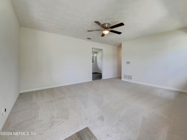 empty room featuring ceiling fan and light carpet