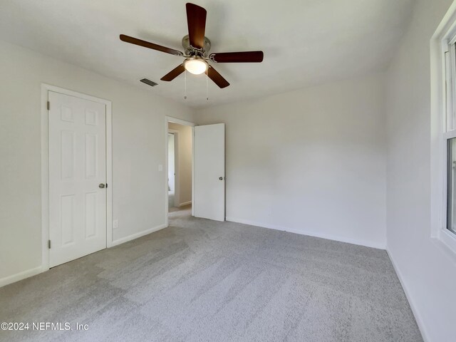 empty room with ceiling fan and light colored carpet