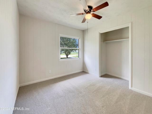 unfurnished bedroom featuring light colored carpet, a closet, and ceiling fan