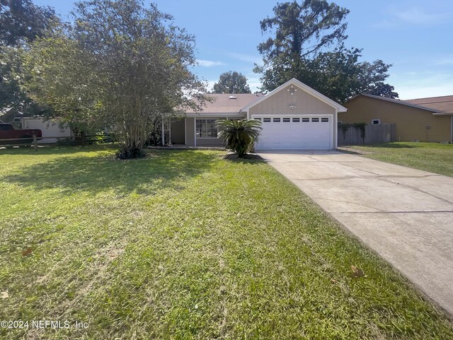 view of front of property featuring a front lawn and a garage